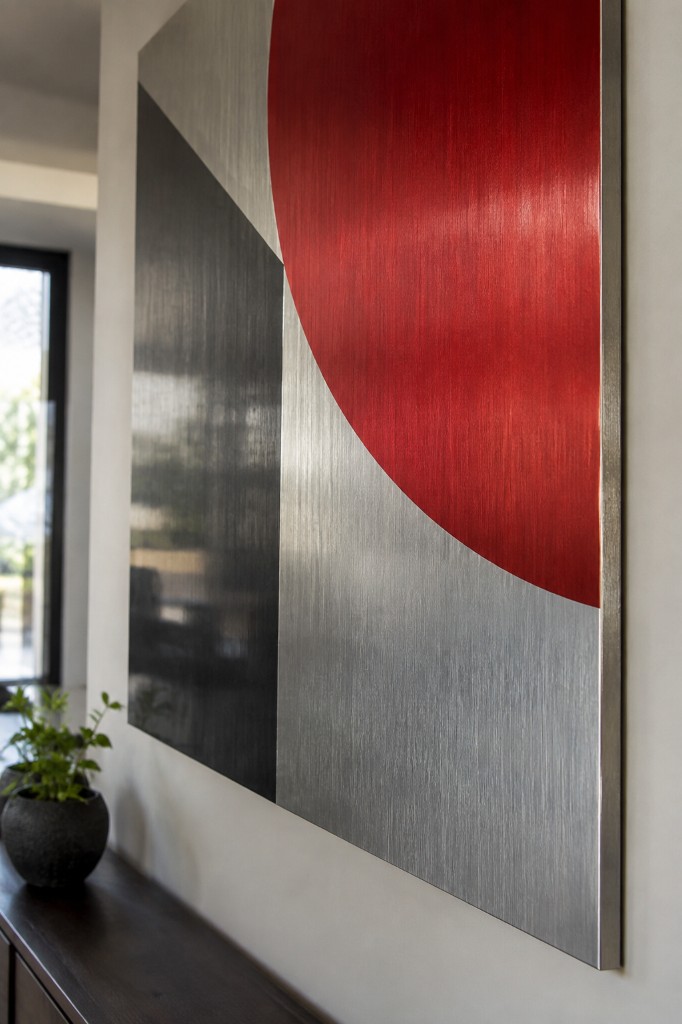 Abstract red and black graphic on a brushed metal panel.